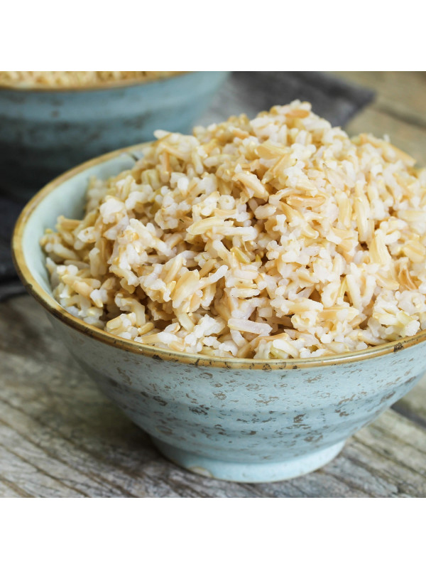 Two bowls of Augason Farms Brown Rice 24lb 4 Gallon Pail - 262 Servings - (SHIPS IN 1-2 WEEKS) on a wooden table.