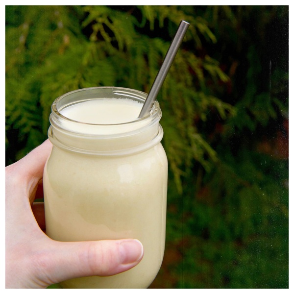 A person holding a mason jar with a non-GMO vanilla shake.