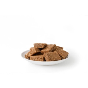 A white bowl filled with pieces of Nutrient Survival Peanut Butter Bar Meals #10 Can 10 Servings - (SHIPS IN 2-4 WEEKS) granola on a white background.