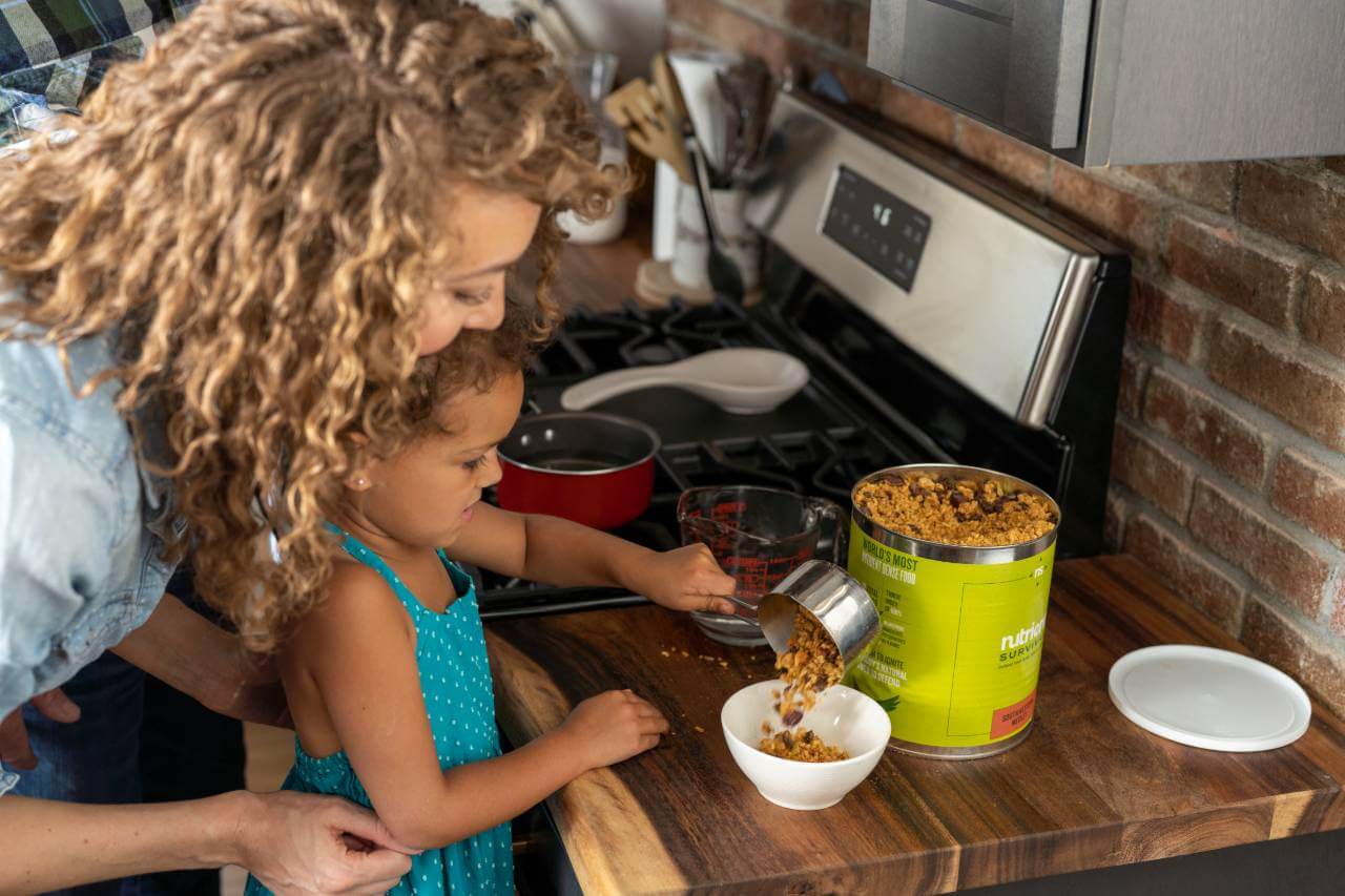 A woman and child preparing Nutrient Survival Southwestern Medley 10 Servings in the kitchen.
