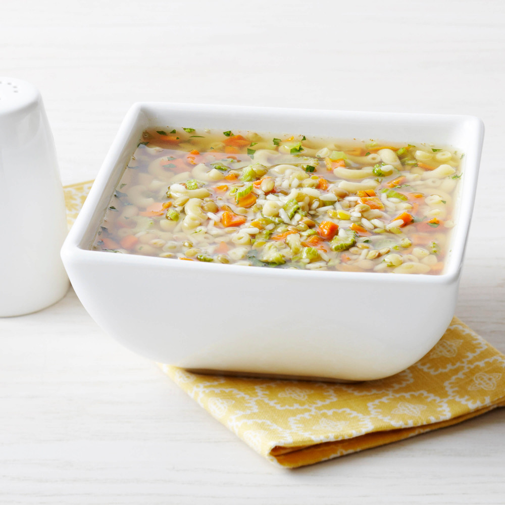 A Augason Farms 1-Week 1-Person Emergency Food Pail - (SHIPS IN 1-2 WEEKS) bowl of soup with vegetables on a yellow napkin.