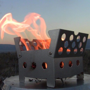 A ReadyWise (formerly Wise Food Storage) Cube Stove + 2 Fire Starters (SHIPS IN 1-2 WEEKS) with flames on top of it.