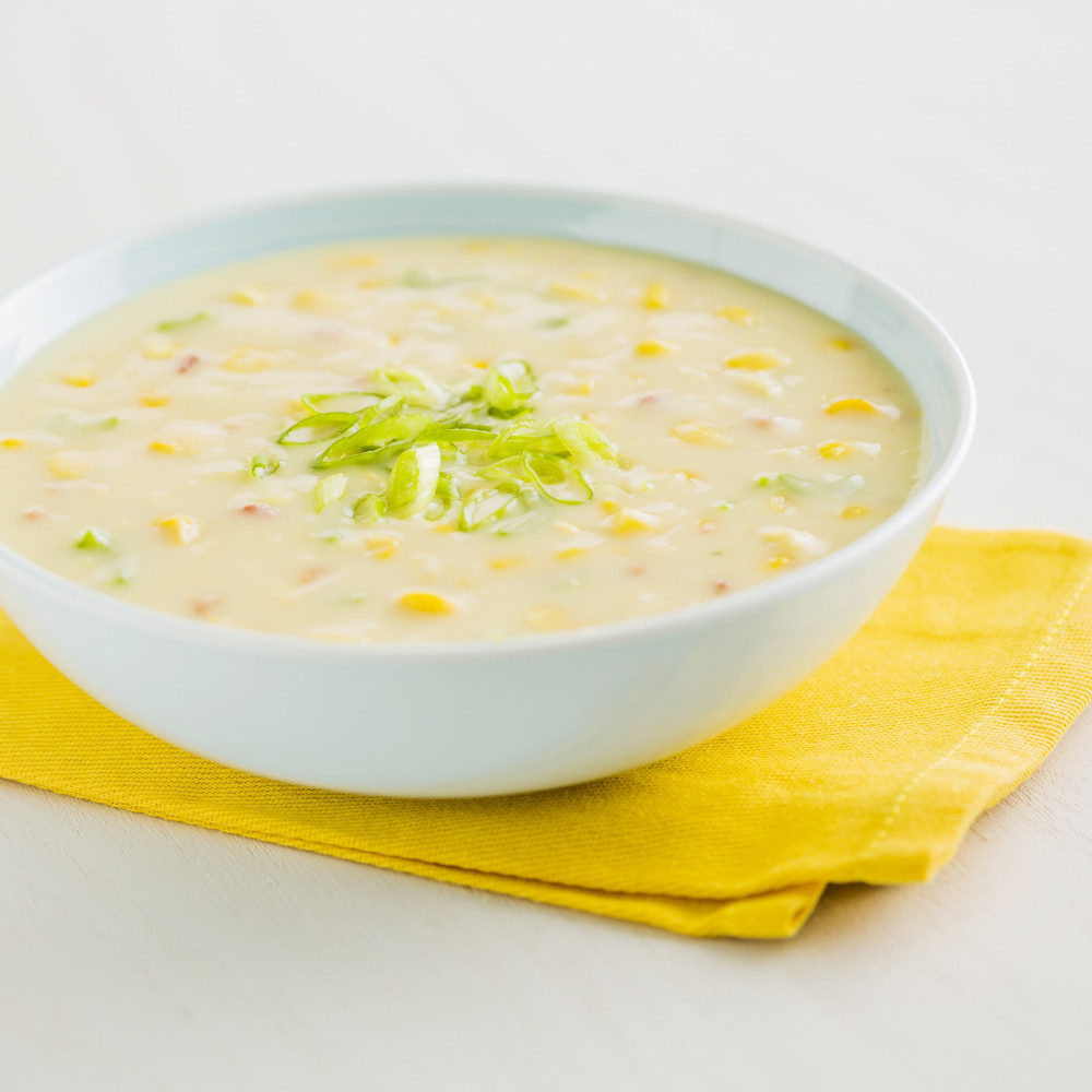 A bowl of Augason Farms Corn Chowder Soup #10 Can - 20 Servings - (SHIPS IN 1-2 WEEKS) on a yellow napkin.