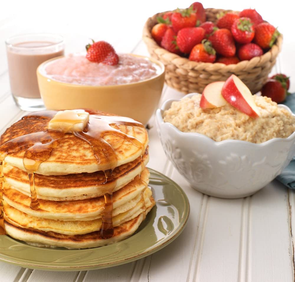 A stack of Legacy Food Storage Emergency Food Ultimate Sample Pack - Survival Supply - 183 Large Servings - (SHIPS IN 1-2 WEEKS), strawberries, and yogurt on a wooden table.