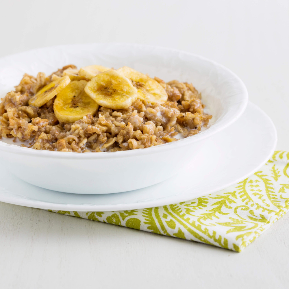 A bowl of oatmeal with Augason Farms Dehydrated Banana Slices 4 Gallon Pail - 151 Servings Bucket - (SHIPS IN 1-2 WEEKS) on a napkin.