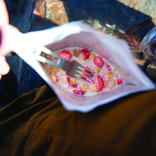 A person holding a Peak Refuel Freeze-Dried Breakfast Sampler Food Storage and Backpacking Food Kit - (SHIPS IN 1-2 WEEKS) in a bag of food.