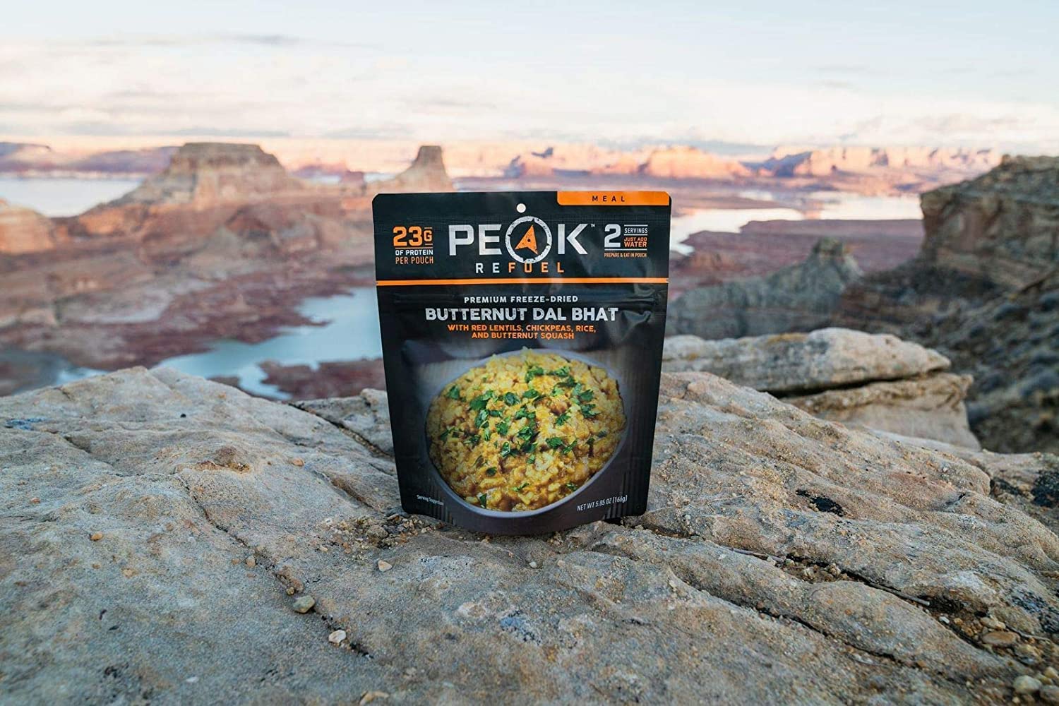 A bag of Peak Refuel Freeze-Dried Breakfast, Lunch, and Dinner Sampler Food Storage and Backpacking Food Kit - (SHIPS IN 1-2 WEEKS) sitting on top of a rocky cliff.