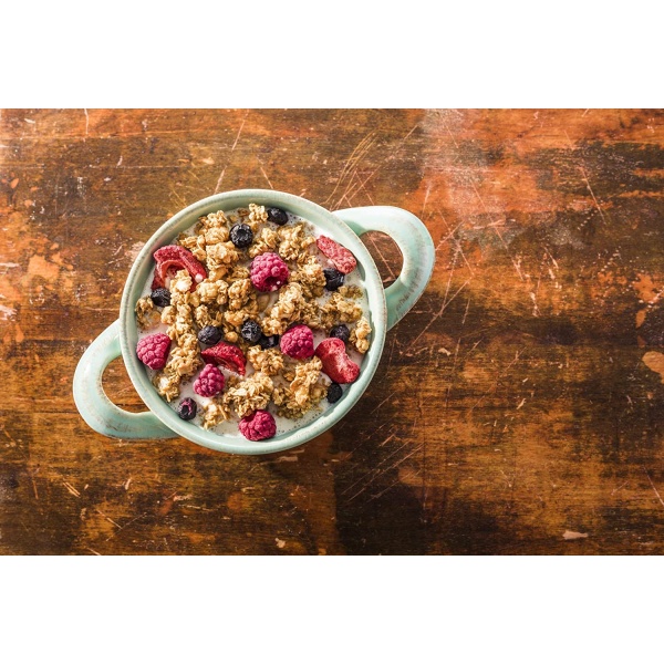 A bowl of Peak Refuel Freeze-Dried Breakfast Sampler Food Storage and Backpacking Food Kit - (SHIPS IN 1-2 WEEKS) and berries on a wooden table.