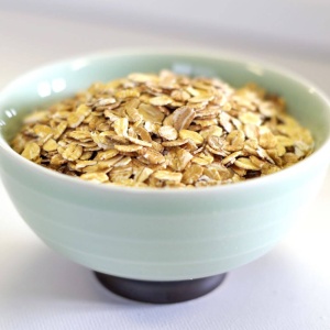 Oats for emergency food storage in a bowl on a white surface.