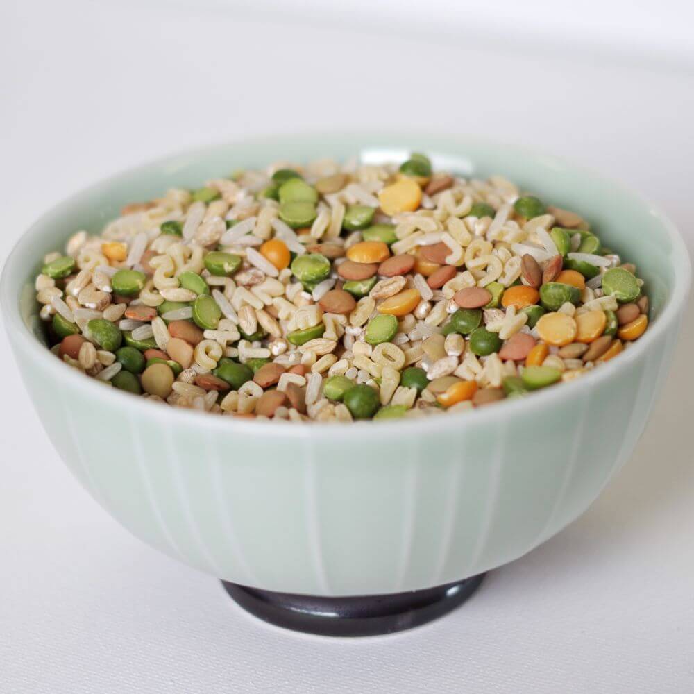 A bowl full of rice and peas for emergency food storage on a white surface.