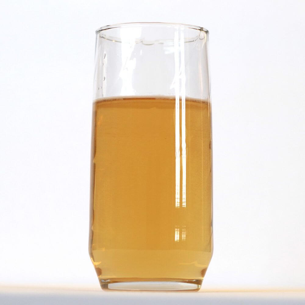 A glass with liquid in it on a white background.