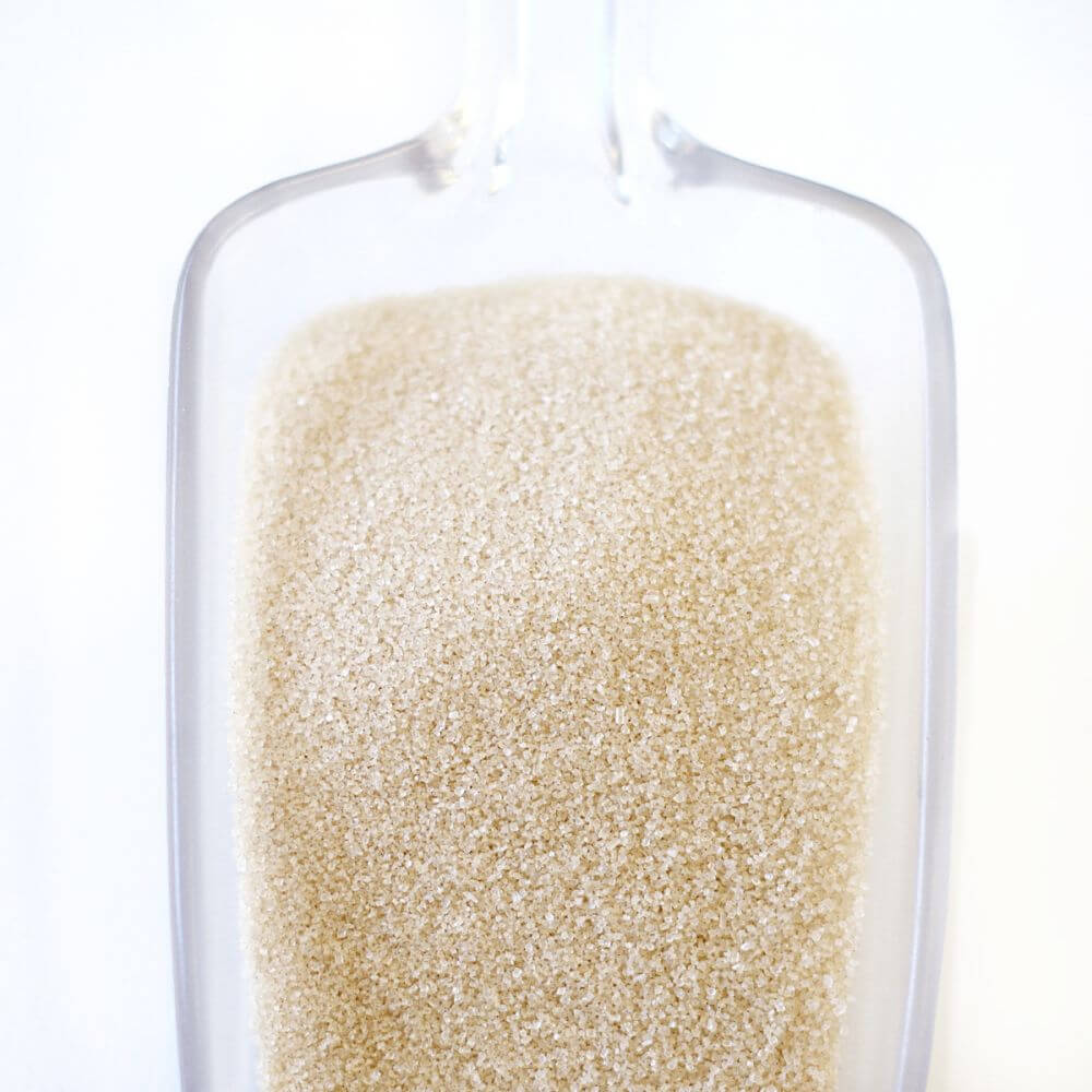 Granulated sugar in a glass measuring cup.