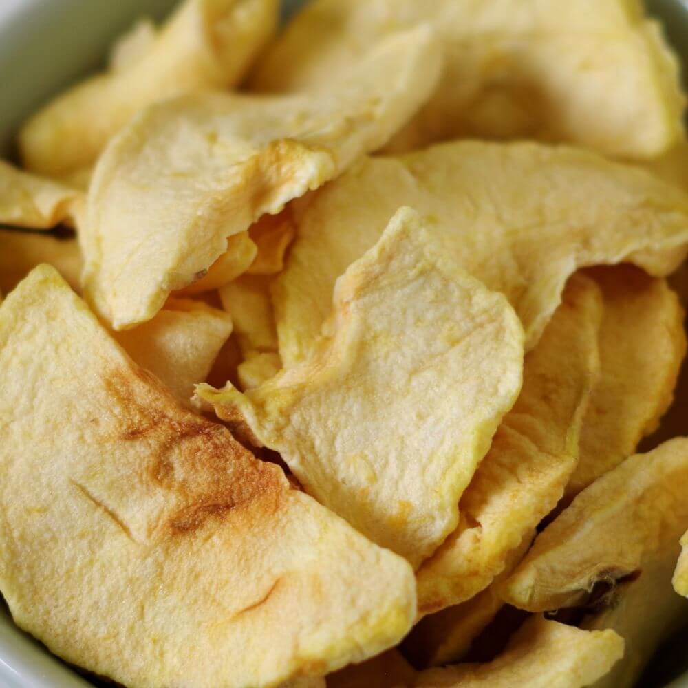 Apple chips in a bowl on a table.