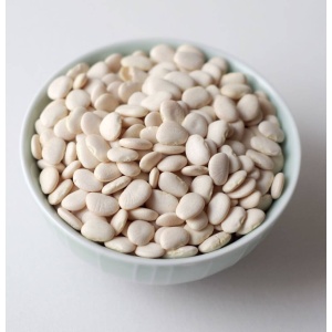 White beans in a bowl on a white surface.