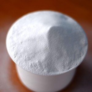 A white powder is sitting on top of a wooden table.
