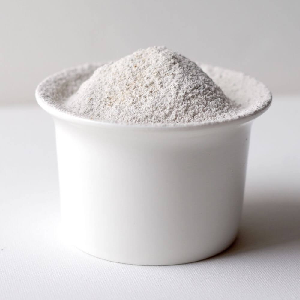 White powder in a white bowl on a white surface.