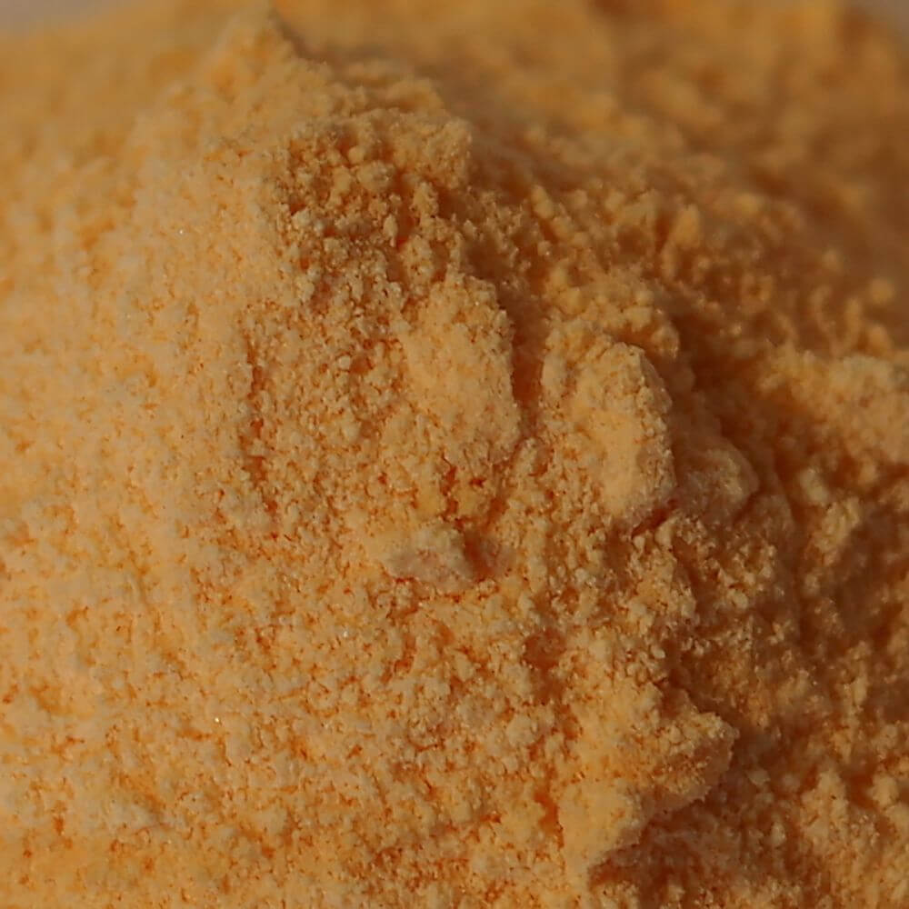 A pile of orange powder on a white surface.