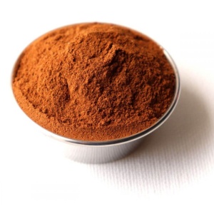 Cocoa powder in a small bowl on a white background.