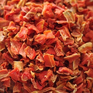 A pile of dried red peppers on a table.