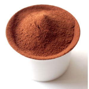 Cocoa powder in a cup on a white background.