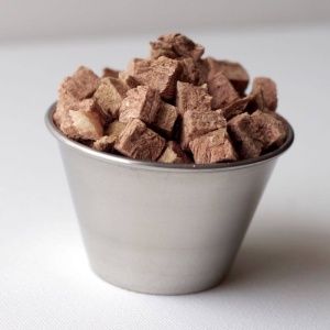 A bowl of chocolate cubes on a white surface.