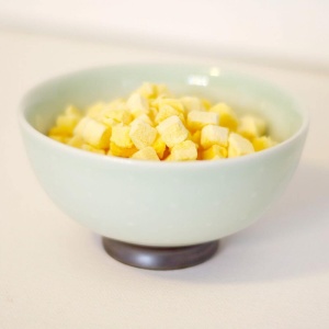 A bowl filled with cubes of pineapple.