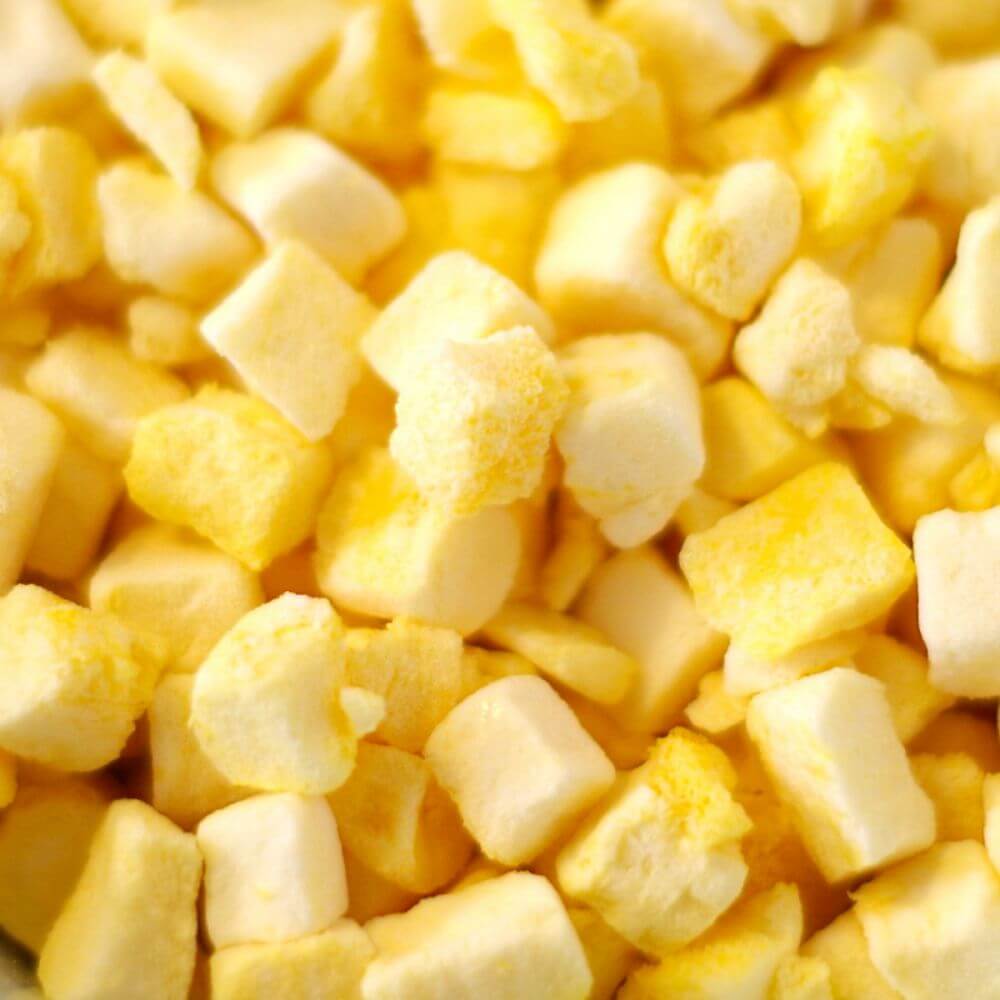 A close up of yellow cubes in a bowl.