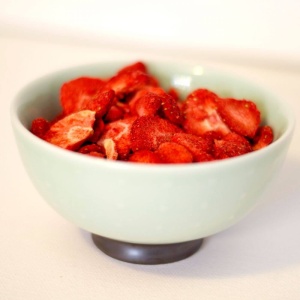 Strawberries in a bowl on a table.