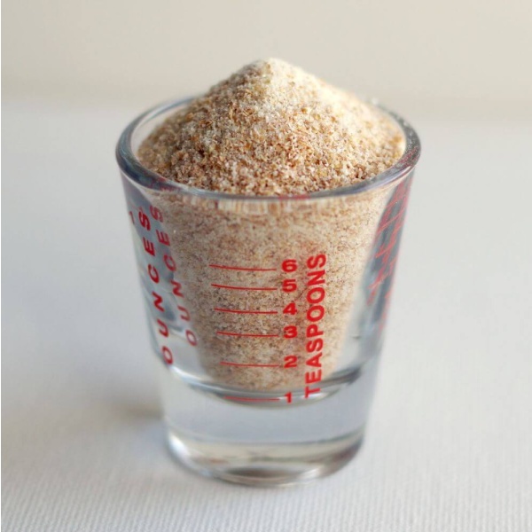 A shot glass filled with granulated sugar.