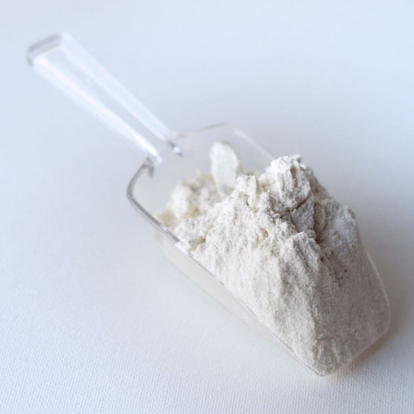 White powder in a scoop on a white surface.