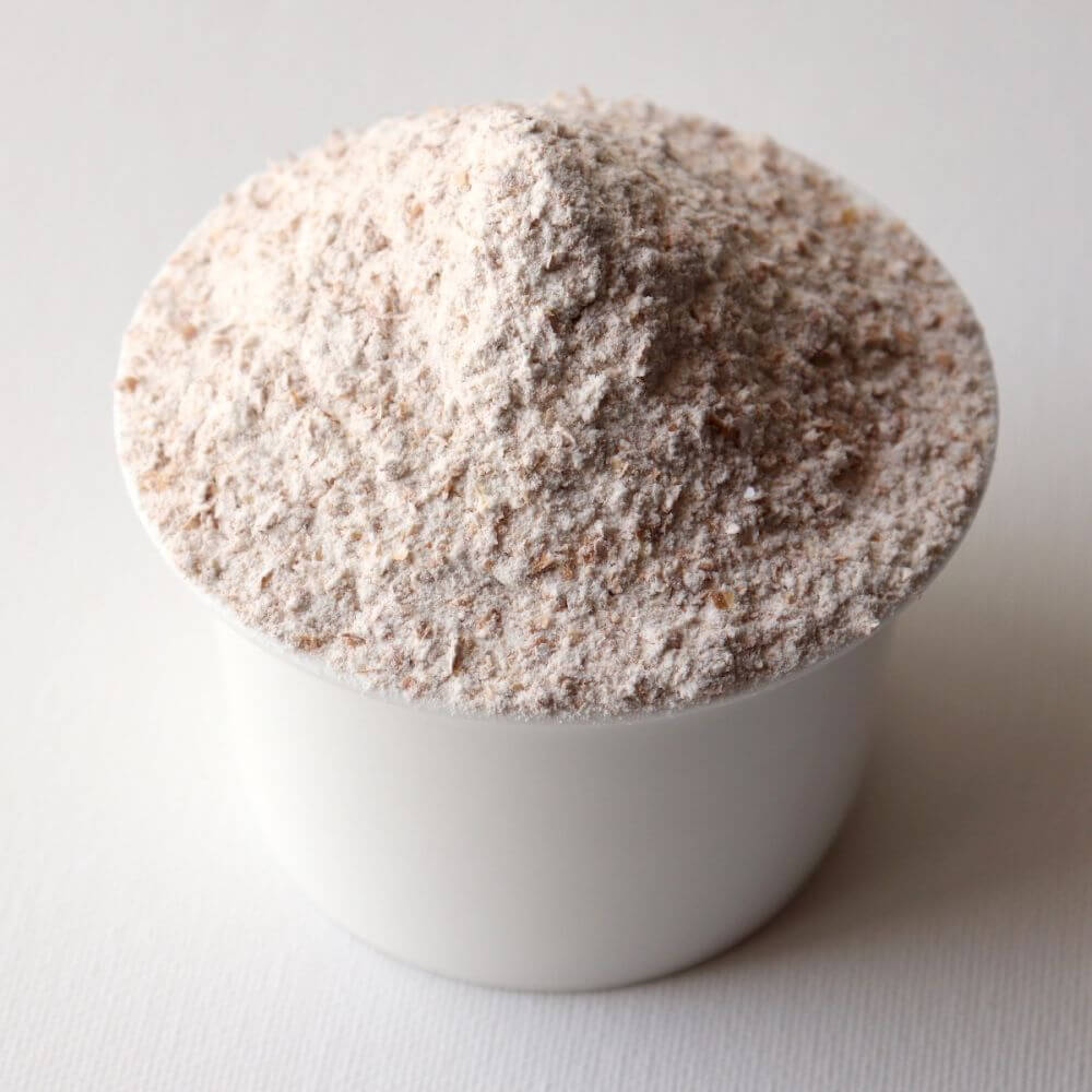 A white bowl of powder on a white surface.