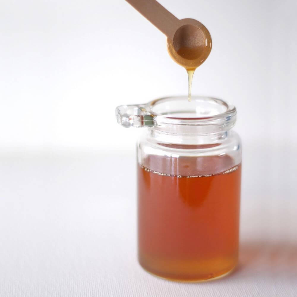 Honey in a jar with a wooden spoon.