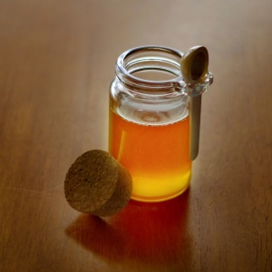 Cox's Honey Gluten-Free Liquid Honey Cox Grade a 5 lbs Pail - 108 Servings - (SHIPS IN 1-4 WEEKS) in a jar on a wooden table.
