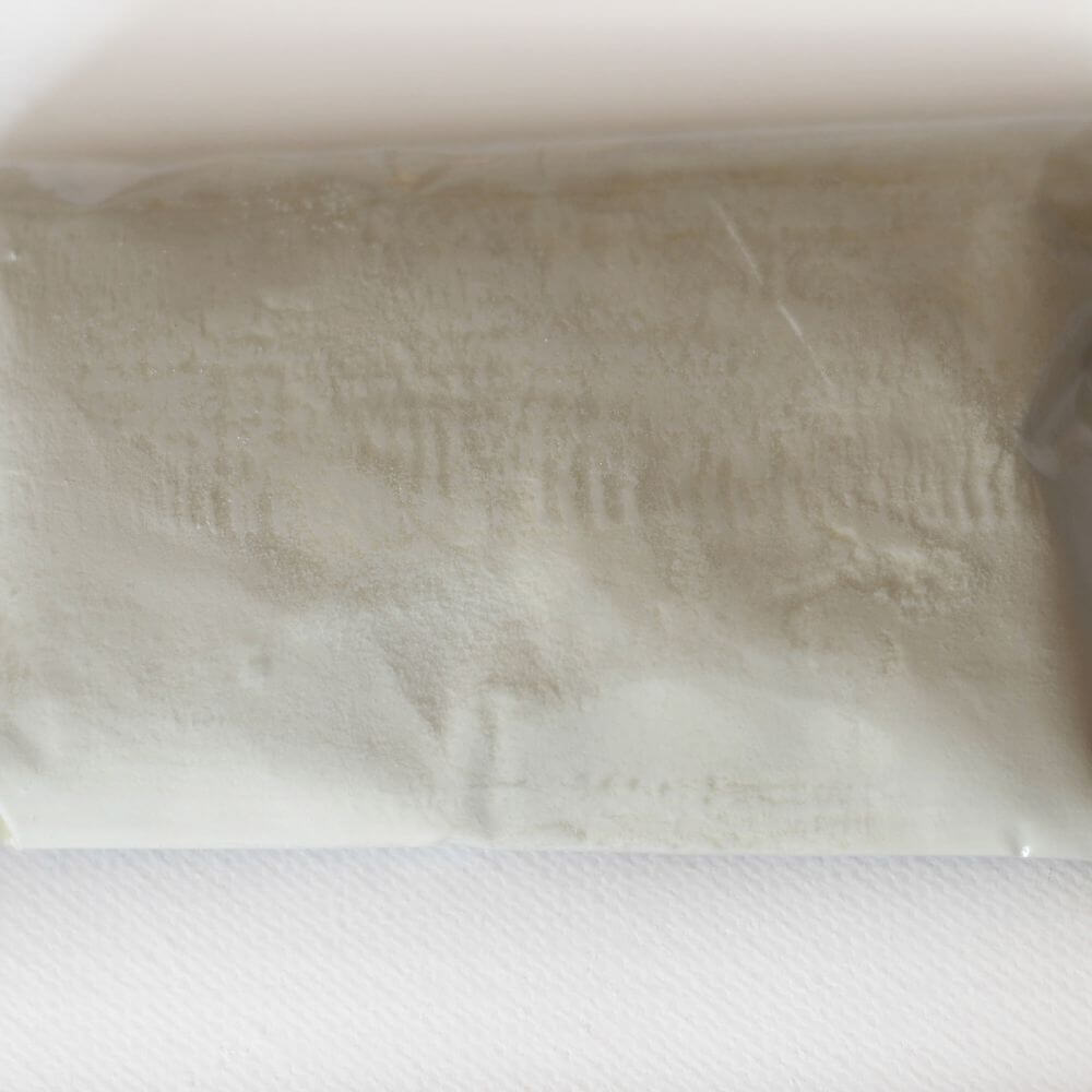 A bag of white powder sitting on top of a white surface.