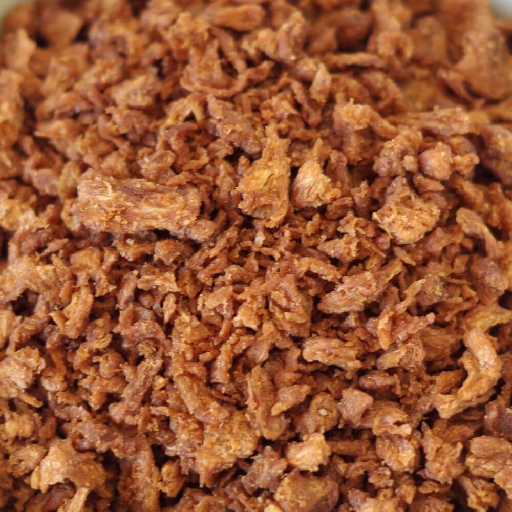 A close up of a bowl of shredded meat.