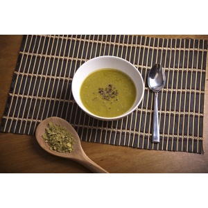 A bowl of NorthWest Fork Green Pea Soup Mix - Non-GMO, Gluten-Free, Kosher, and Vegan - 15 Servings - (SHIPS IN 1-3 WEEKS) next to a wooden spoon.