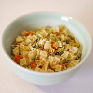 A bowl of pasta with vegetables, ideal for emergency food storage.