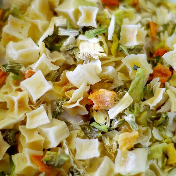 A bowl of pasta with vegetables, suitable for emergency food storage.