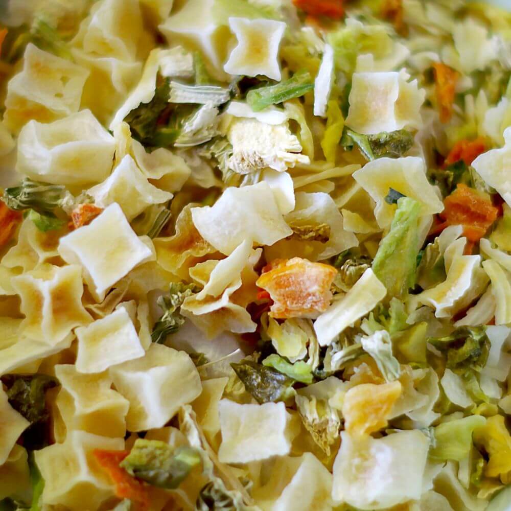 A bowl of pasta with vegetables in it, ideal for emergency food storage.