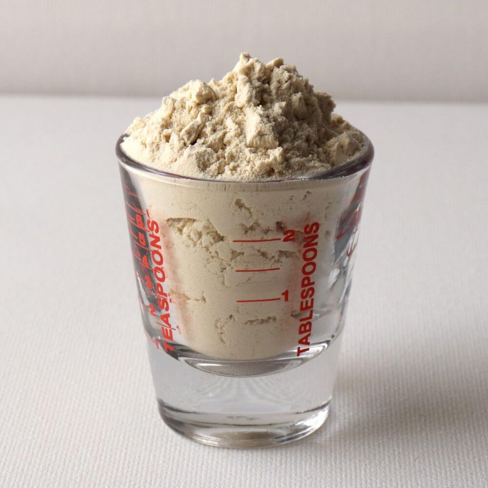 A shot glass with a scoop of granola for emergency food storage.