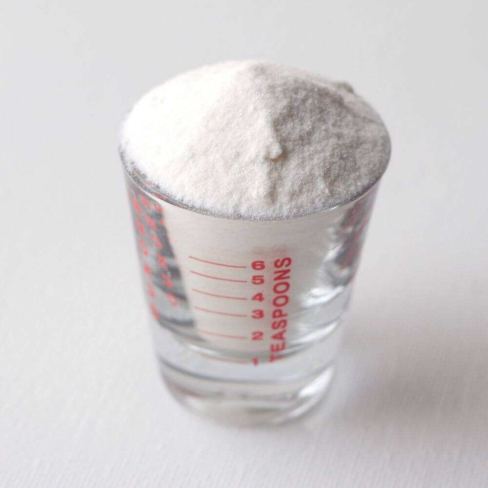 A white powder for emergency food storage in a measuring glass.