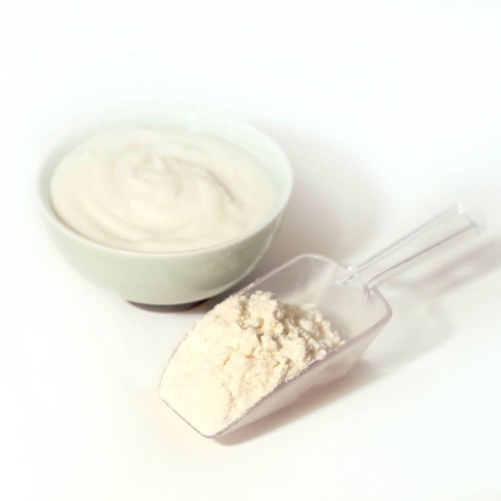 A bowl of yogurt, perfect for emergency food storage, is accompanied by a spoon.