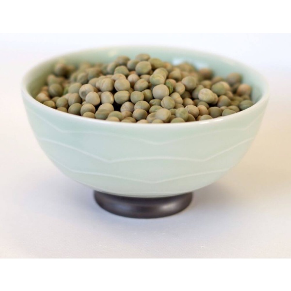 Peas in a bowl are ideal for emergency food storage on a white surface.