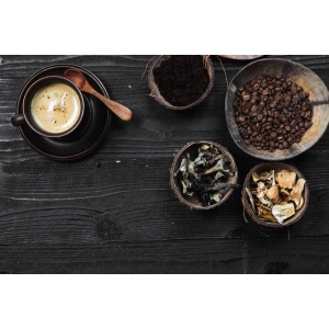 Organic coffee beans and a spoon on a wooden table.
