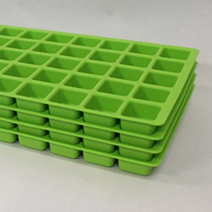 Green silicone ice cube trays on a white surface.
