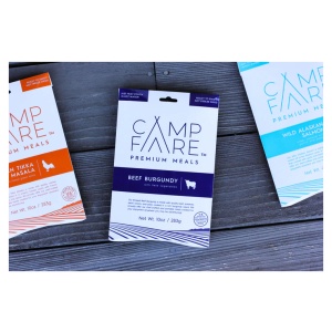 Three packages of Campfare premium meals on a wooden table.