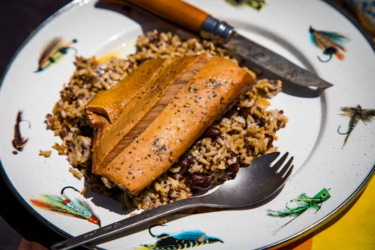 A plate of Campfare Wild Alaskan Salmon with rice, knife, and fork.