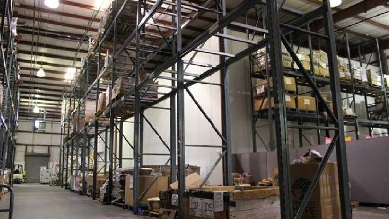 A warehouse with boxes and pallets, stock levels very low.