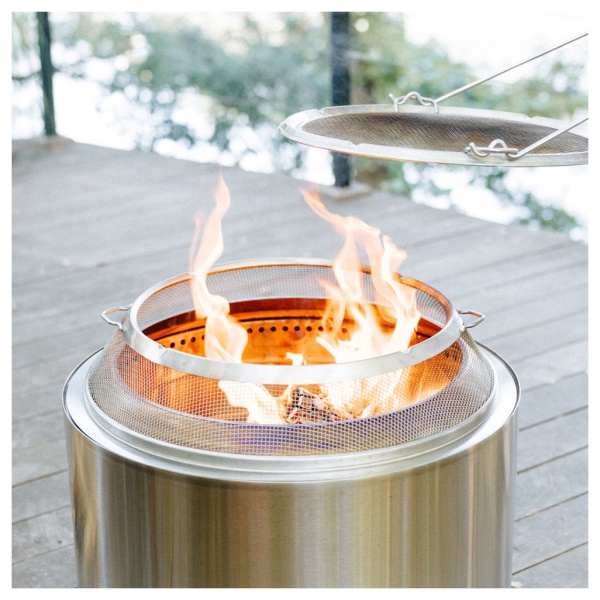 A portable stainless steel fire pit on a wooden deck.