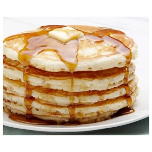 A stack of buttermilk pancakes with syrup and butter on a plate.